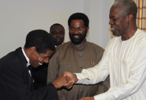 Haile Gebreselsie giving a book to Vice-President Amissah-Arthur