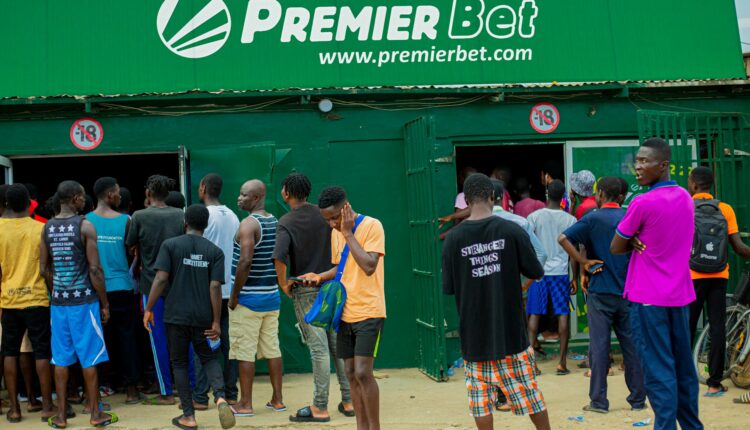 Young men waiting in queue to enter betting centre