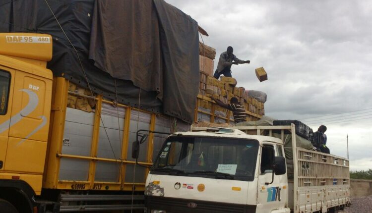 An overloaded truck shedding off the excess goods before it is allowed to move